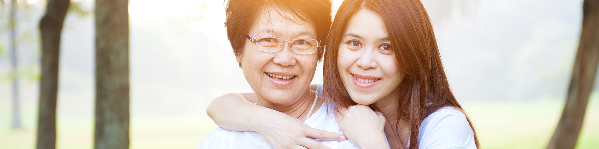 a nurse hugging her elderly patient on the park.